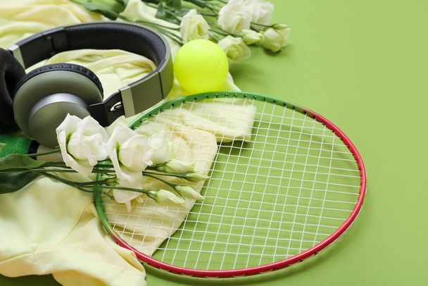 Composition with sports equipment, modern headphones, clothes and flowers for International Women's Day on green background, closeup - Photo, Image