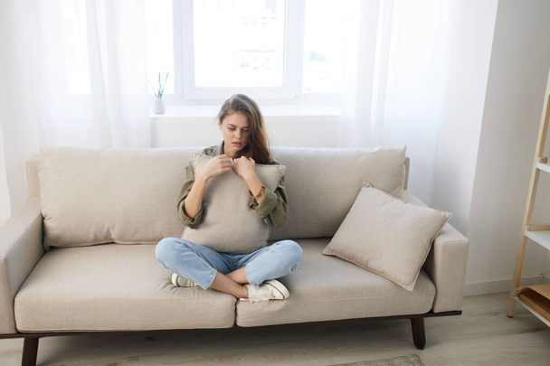 Μοναχική γυναίκα σε έναν θλιμμένο καναπέ: Οι οδυνηρές αντανακλάσεις της ψυχικής υγείας - Φωτογραφία, εικόνα