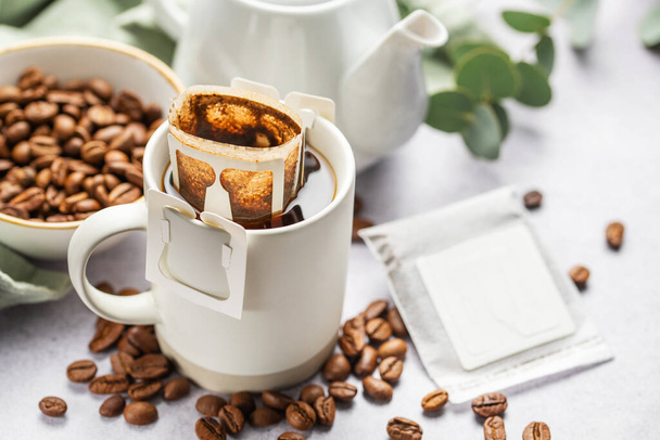 Kapací kávový sáček s mletou kávou v šálku. Vaření čerstvě uvařené kávy doma.   - Fotografie, Obrázek