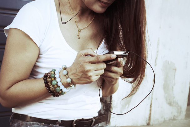 Woman listening to music on earphone with smart phone  - Foto, imagen
