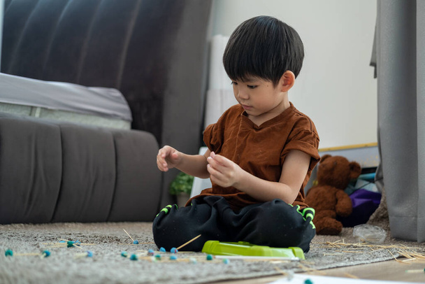 Asyalı çocuk odada plastikle oynuyor. - Fotoğraf, Görsel