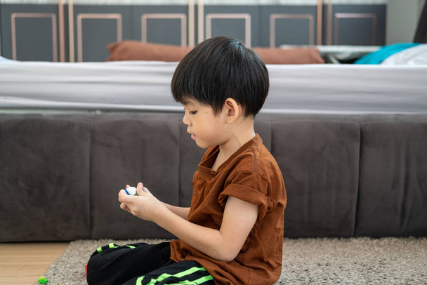 Asyalı çocuk odada plastikle oynuyor. - Fotoğraf, Görsel