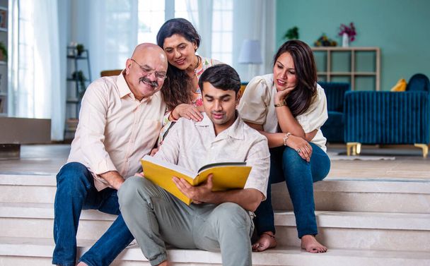 Famille indienne regardant album photo assis sur le canapé, moment heureux - Photo, image