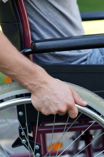 Niepełnosprawny mężczyzna korzystający z wózka inwalidzkiego w parku. Wysokiej jakości zdjęcie - Zdjęcie, obraz