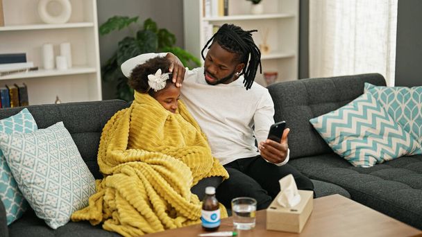 Afroamericanos padre e hija teniendo consulta médica en línea estando enfermo en casa - Foto, Imagen