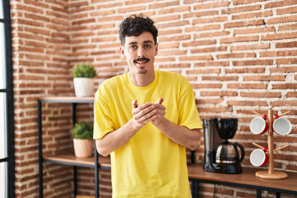Young caucasian man holding cup of coffee standing at home - Fotografie, Obrázek
