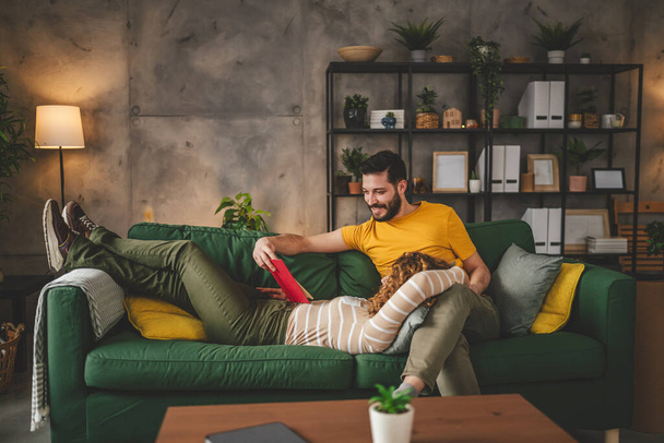 мужчина и женщина кавказская взрослая пара читают дома на диване - Фото, изображение