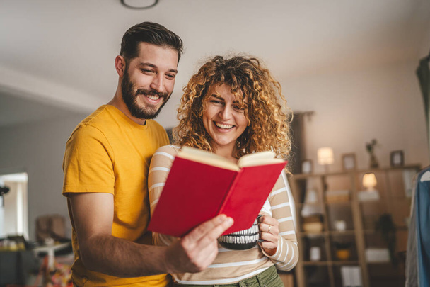 portrait of man and woman caucasian adult couple with book at home - Photo, Image