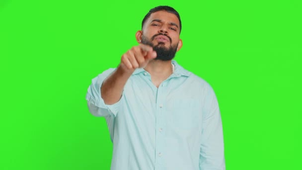 I choose you. Indian smiling man pointing finger to camera and looking with playful happy expression, making winner choice, showing direction. Arabian young guy isolated on green chroma key background - Footage, Video