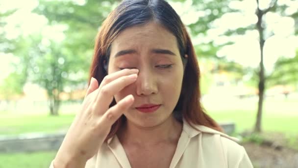 jonge aziatische vrouw heeft visie problemen heeft stof allergieën gebruikt handen wrijven of krassen haar ogen heeft jeukende ogen en geïrriteerde ogen van stof problemen onzuiverheden in de lucht en stuifmeel bloem stuifmeel.  - Video