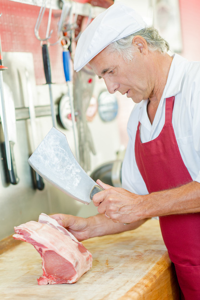 Butcher chopping some pork - Foto, Imagen