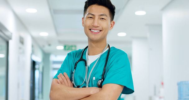Kasvot, lääkäri ja luottavainen hymyillen sairaalassa kädet ristissä johtajuutta lääketieteessä. Aasialainen mies, henkilö tai sairaanhoitaja kardiologiassa, ensiavussa tai terveydessä potilaan hoitoon klinikalla. - Valokuva, kuva