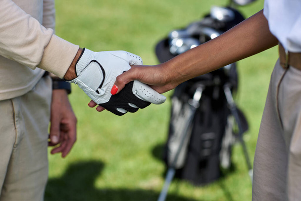 Крупный план двух игроков в гольф, пожимающих руку после матча на открытом воздухе - Фото, изображение