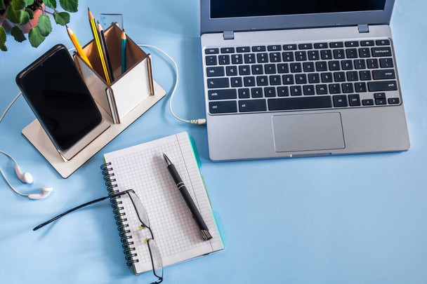 Munkahelyi laptop, jegyzettömb és okostelefon kék asztali - Fotó, kép