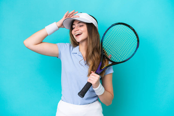 młoda tenisistka kobieta odizolowany na niebieskim tle uśmiechając się dużo - Zdjęcie, obraz