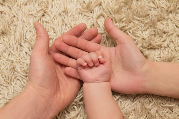parents hold the child's hand - Φωτογραφία, εικόνα