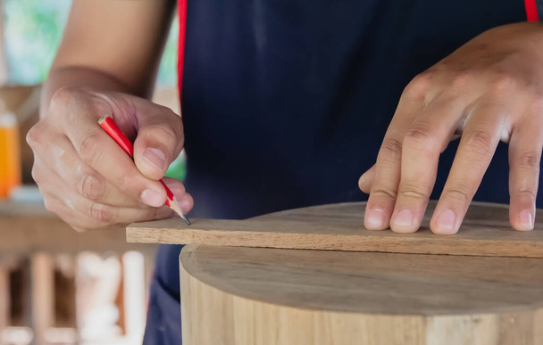 artesano utilizando la marca de lápiz hacer en el producto de madera que trabaja en el proyecto de muebles de carpintería taller  - Foto, Imagen