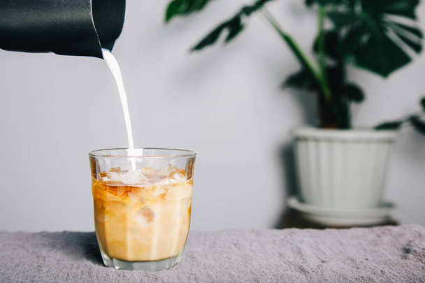 глечик Налийте молоко, роблячи лате каву на стіл і кавоварку. домашня кава - Фото, зображення