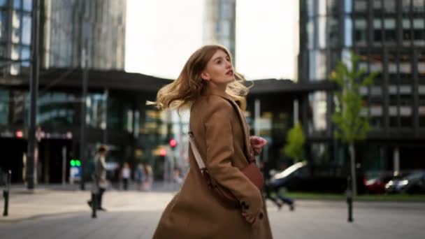 Back view of the stylish businesswoman looking for destination and running at business district. Portrait gorgeous realtor strolling street and looking camera - Footage, Video