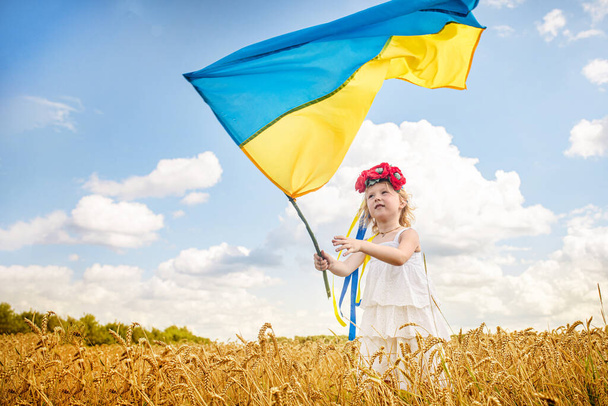 lány gazdaság zászló Ukrajna. Kék sárga zászló Ukrajna kezében gyermek a függetlenség napján és a zászló napján - Fotó, kép