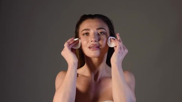 白いスポンジで顔を拭く若い女性. フェイシャルスキンケア。 高品質のフルHD映像 - 映像、動画