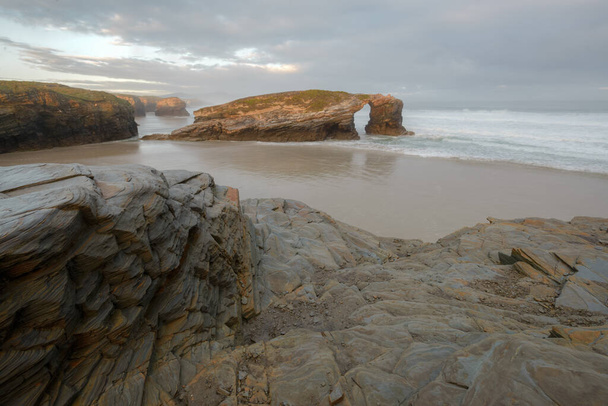 O famoso arco rochoso visível na maré baixa na praia Como Catedrais em Ribadeo Lugo Galiza - Foto, Imagem