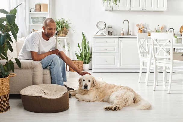 Африканський американець з міастенією сидить поруч зі своїм собакою-лабрадором на дивані вдома. - Фото, зображення
