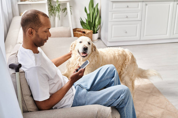 Ein behinderter Afroamerikaner mit Myasthenia gravis entspannt sich zu Hause neben seinem treuen Labrador-Hund. - Foto, Bild