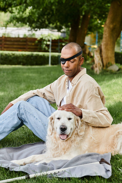 An African American man with myasthenia gravis syndrome sits in the grass with his loyal Labrador dog, embracing nature and each others company. - Photo, Image