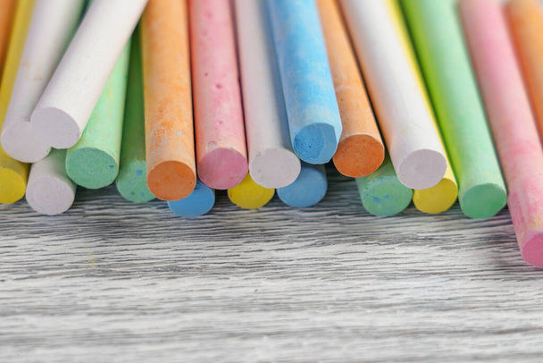Craies multicolores aux couleurs pastel pour des activités créatives sur une planche texturée close up - Photo, image