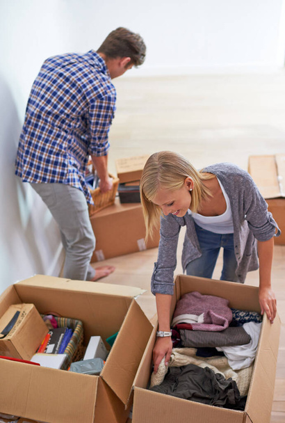 Couple, boxes and packing clothes for moving or homeowner, real estate property or marriage. Man, woman and happy or organize for new apartment or mortgage investment for relocation, buying or rent. - Photo, Image