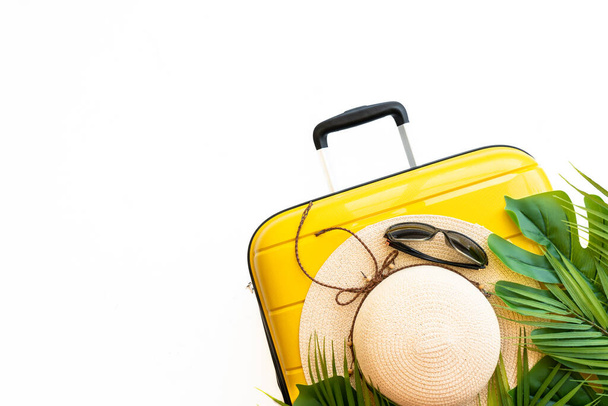 Vacances d'été, concept de voyage. Valise, chapeau et feuilles de palmier sur fond blanc. Pose plate avec espace pour le texte. - Photo, image