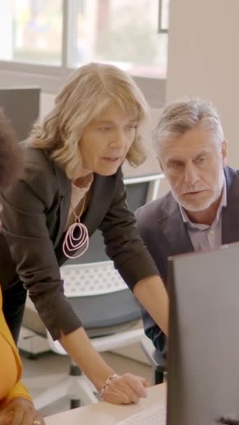 Vidéo au ralenti de trois équipes d'entreprises multiculturelles utilisant un ordinateur et discutant dans un bureau de coworking - Séquence, vidéo