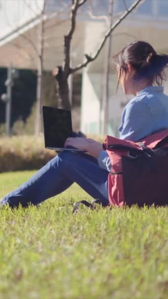 Egy egyetemi hallgató, aki a laptopjával a kampuszon tanul, magába foglalja a kültéri nyugalmat, magabiztos az e-learning utazásában.. - Felvétel, videó