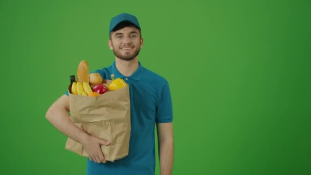 Green Screen Delivery Man hozza papír táska élelmiszerrel. Futár az úton, hogy átadja a rendet egy ügyfélnek. Deliveryman Worker szállít Online rendelés ügyfél. - Felvétel, videó
