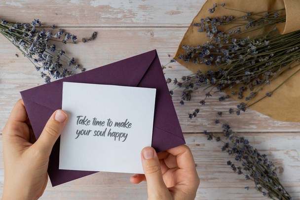TAKE TIME TO MAKE YOUR SOUL HAPPY text on supportive message paper note reminder from green envelope. Flat lay composition dry lavender flowers. Concept of inner happiness, slowing-down digital detox personal fulfillment. Top view - Photo, Image