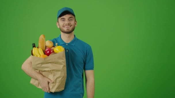 Green Screen Delivery Man bringt Papiertüte mit Lebensmitteln. Kurier auf dem Weg zur Bestellung an einen Kunden. Zusteller liefern Online-Bestellung an Kunden. - Filmmaterial, Video