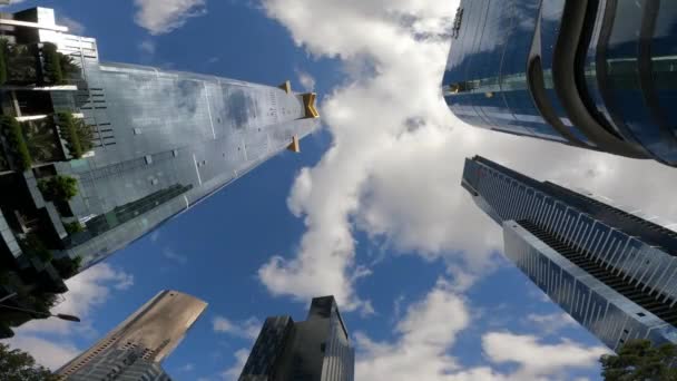 Melbourne ponto de vista paisagem urbana POV de baixo, com alto, edifício imponente refletindo as nuvens cumulus e céu azul  - Filmagem, Vídeo