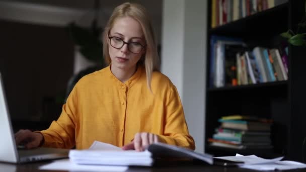 Жінка в жовтій сорочці обробляє рахунки самі вдома - Кадри, відео