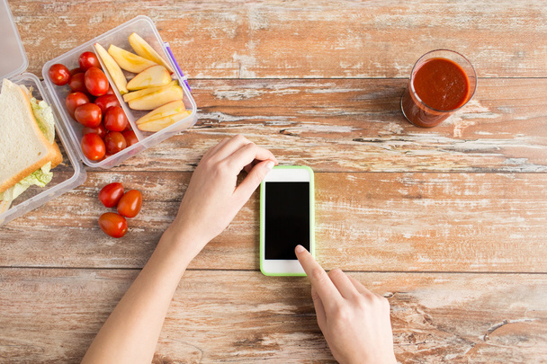 close up of hands with smartphone food on table - Fotó, kép
