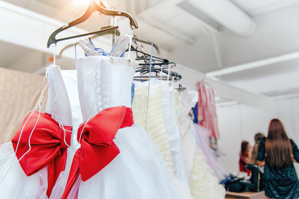 Řada svatebních šatů visí, svatební šaty s velkým rad luk, svatební obchod nebo výstava - Fotografie, Obrázek