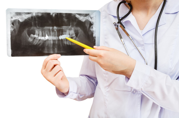 Enfermera señala en imagen de rayos X con mandíbula humana
 - Foto, imagen