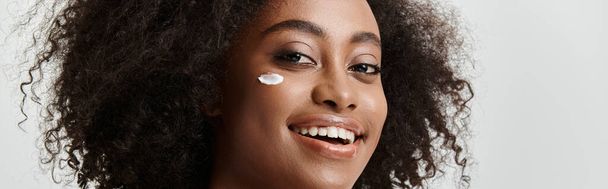 Kaunis nuori afroamerikkalainen nainen, jolla on kiharat hiukset, välittäen puhdasta onnea kirkas hymy kasvoillaan. - Valokuva, kuva
