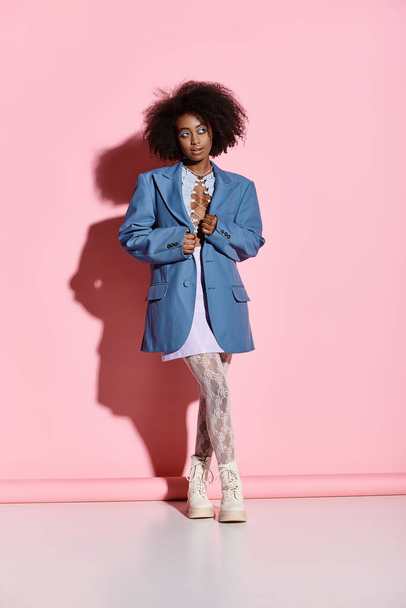 Модная афроамериканка с кудрявыми волосами уверенно стоит перед буйной розовой стеной. - Фото, изображение