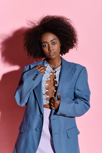 Стильная молодая афроамериканка с вьющимися волосами в синей куртке и белом платье в студии. - Фото, изображение