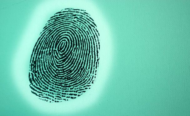 Black fingerprint on a green background - Photo, Image