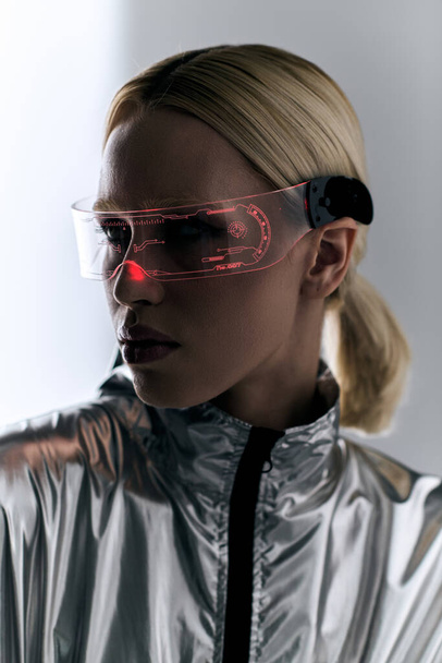 グレーの背景を見下ろすロボットの銀の装飾の未来的な眼鏡を持つ美しい女性 - 写真・画像