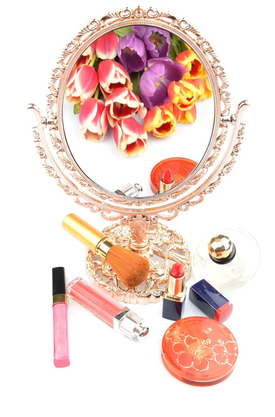 Antieke vergulde spiegel als gevolg van een boeket van bloemen tulpen en vrouwen cosmetica en make-up op een witte achtergrond - Foto, afbeelding