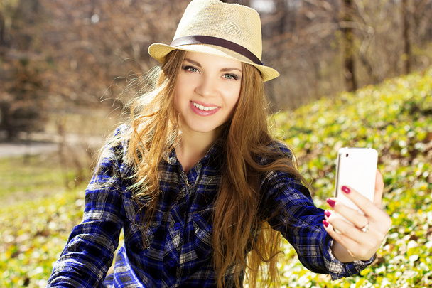 Beautiful young blonde in a hat with a phone - Foto, imagen