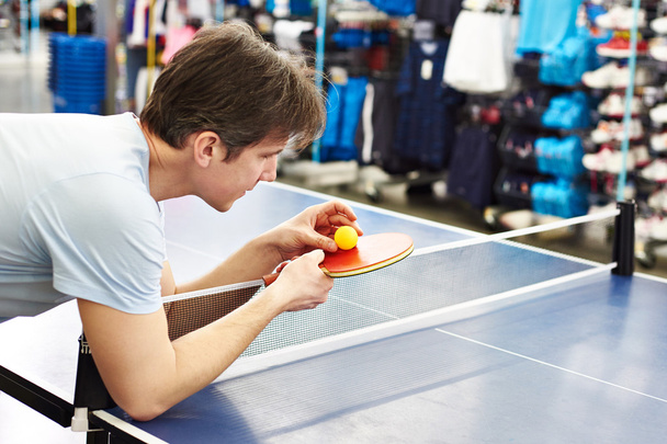 Man chooses table tennis racquet in shop - Valokuva, kuva
